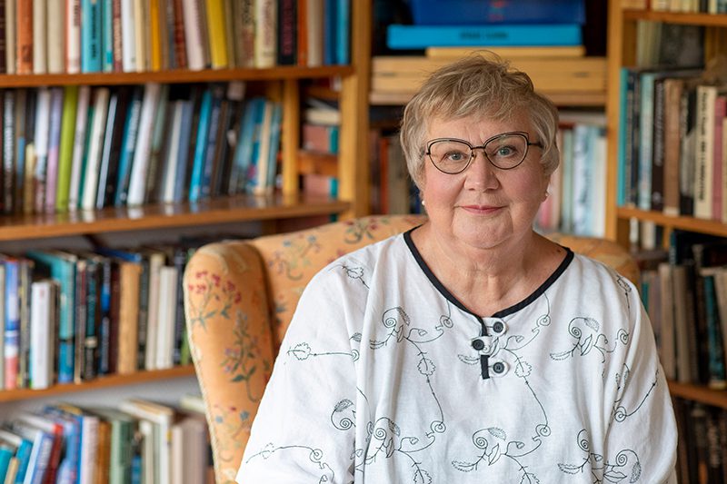 Anneli_Kanto Anneli Kanto kirjahyllyn edessä.