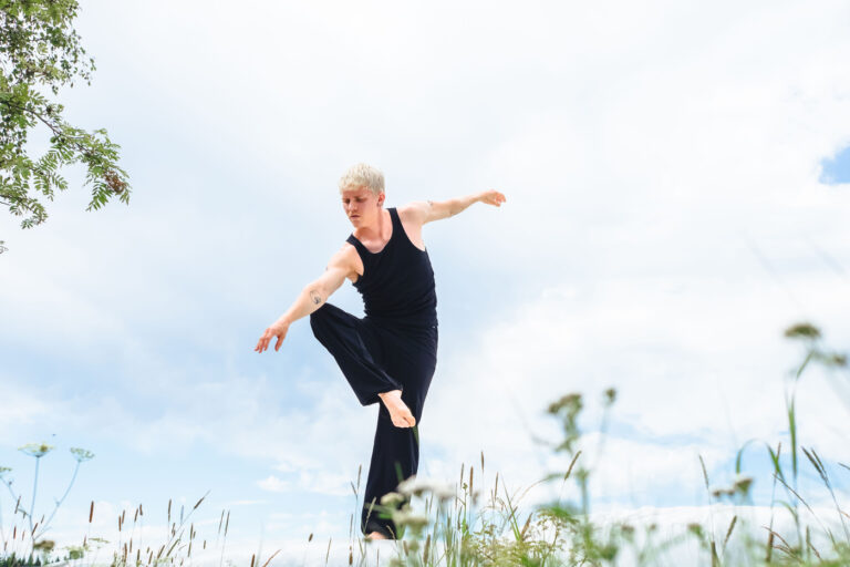 Mieshahmo tanssimassa, taustalla vaalea taivas.