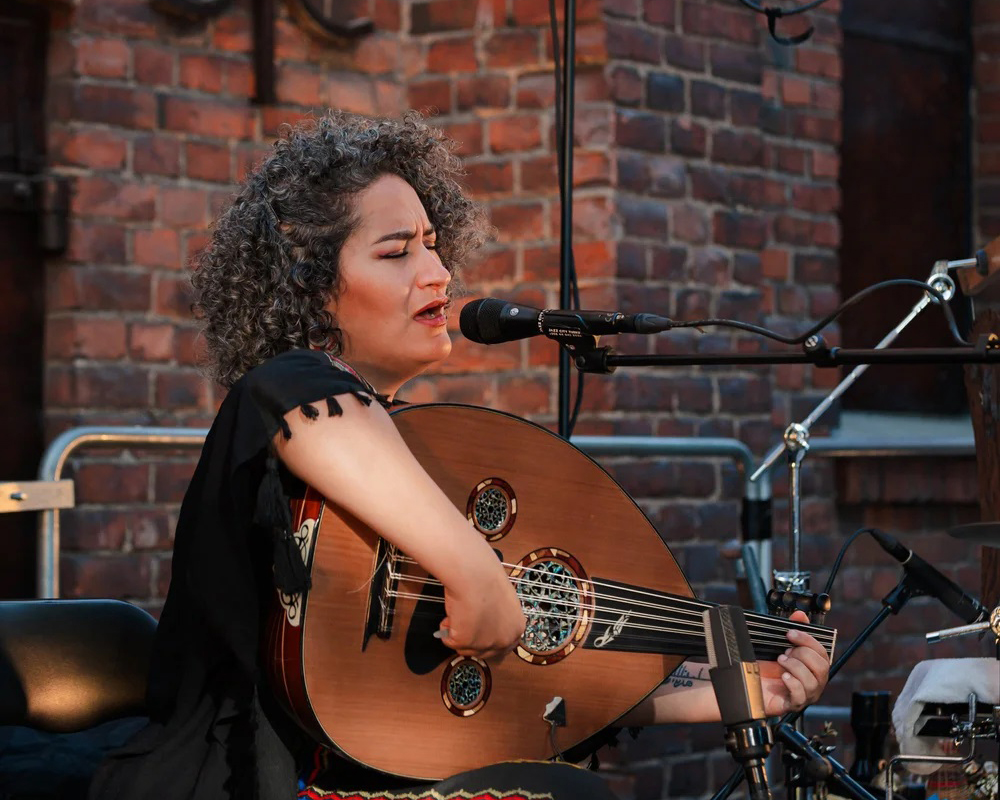 Nemat Battah soittimensa kanssa laulamassa.