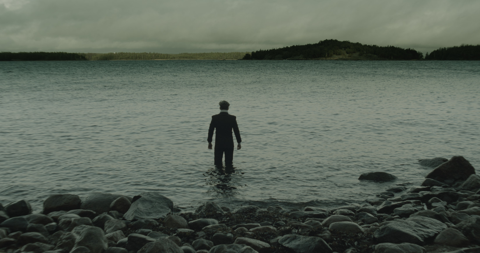 Henkilö kävelemässä rannalta veteen.