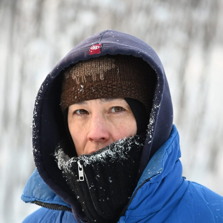 Taiteilija Anna Ruth talvisessa maisemassa, vaatteissa on jäähilettä.
