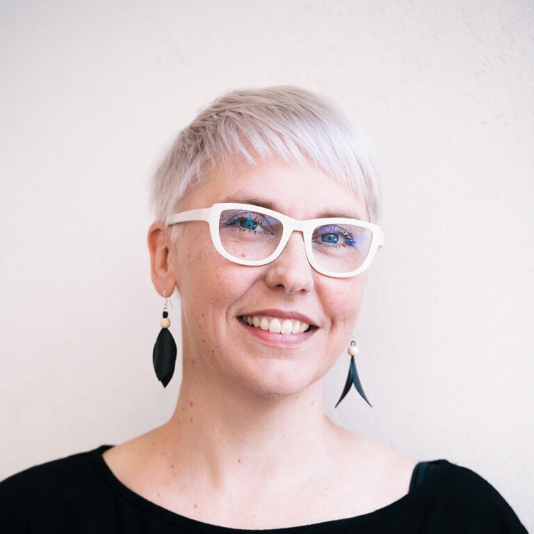 Taiteilija Raisa Foster valkoisissa silmälaseissa.